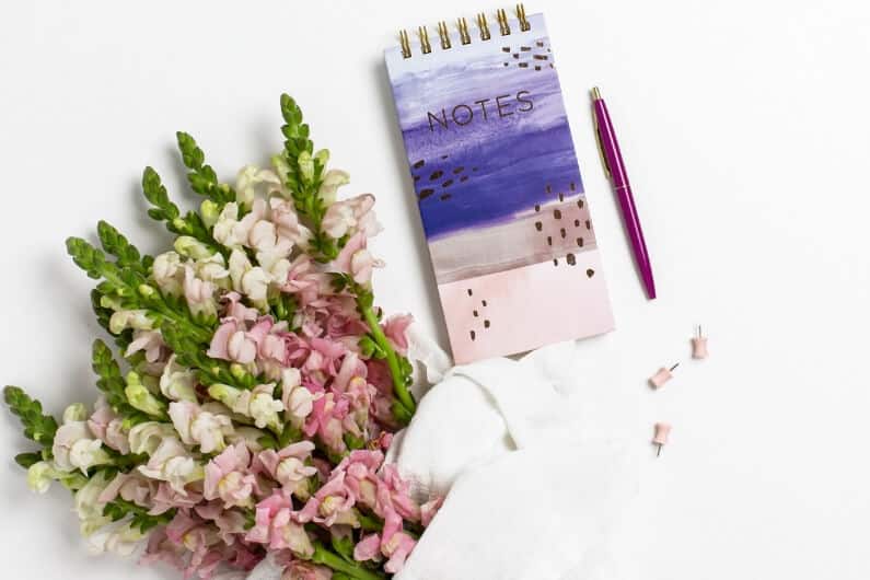 Notebook and flowers on a desk