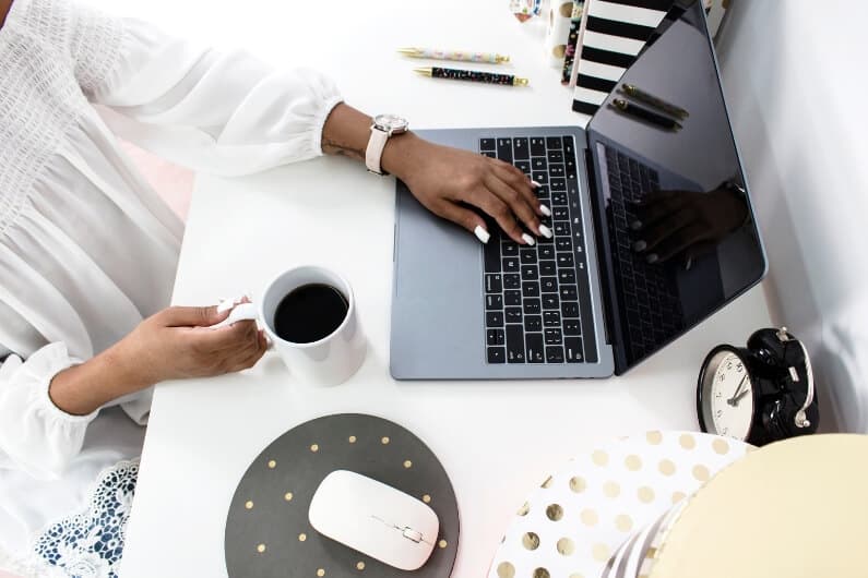 Virtual Assistant Working at her desk and drinking coffee