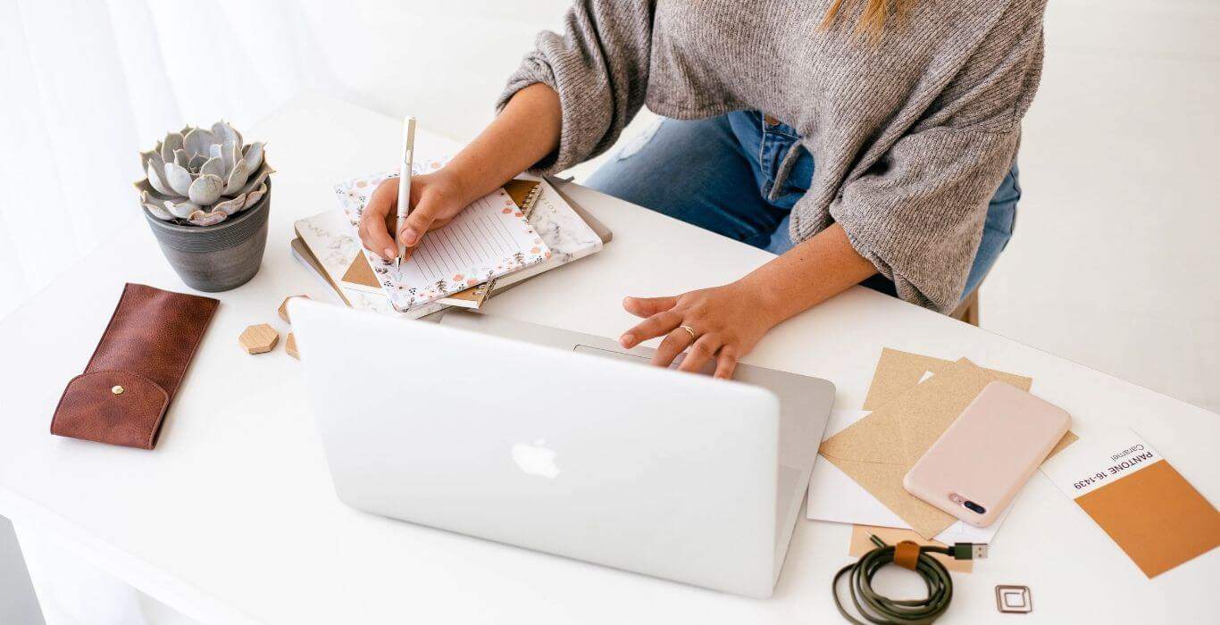 woman sitting at desk planning which wordpress plugins she needs for her business website