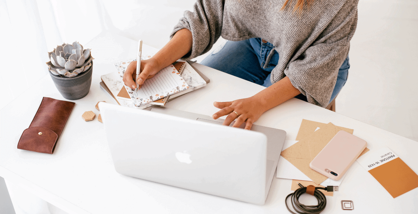 woman taking notes at her desk about how to make sure her website makes a great first impression