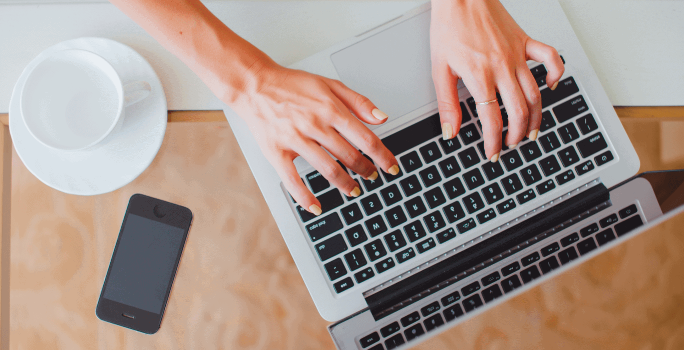 woman's hands typing at a keyboard